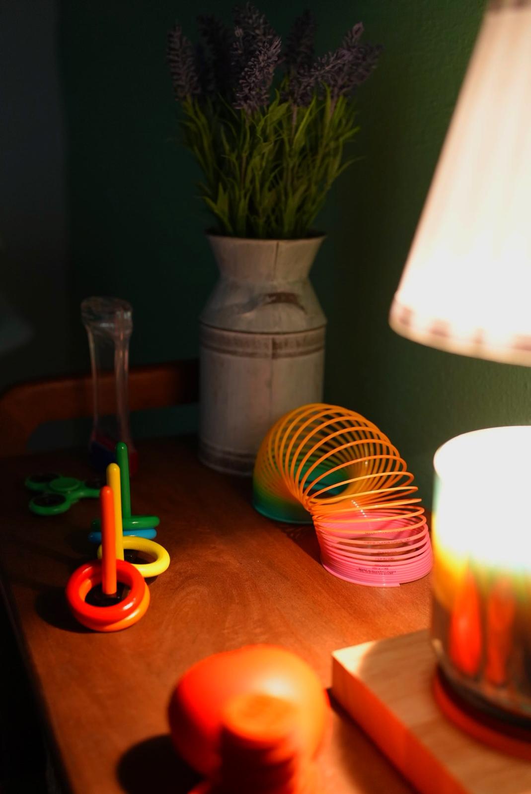 Materiales sensoriales de colores junto a una lámpara y un florero.