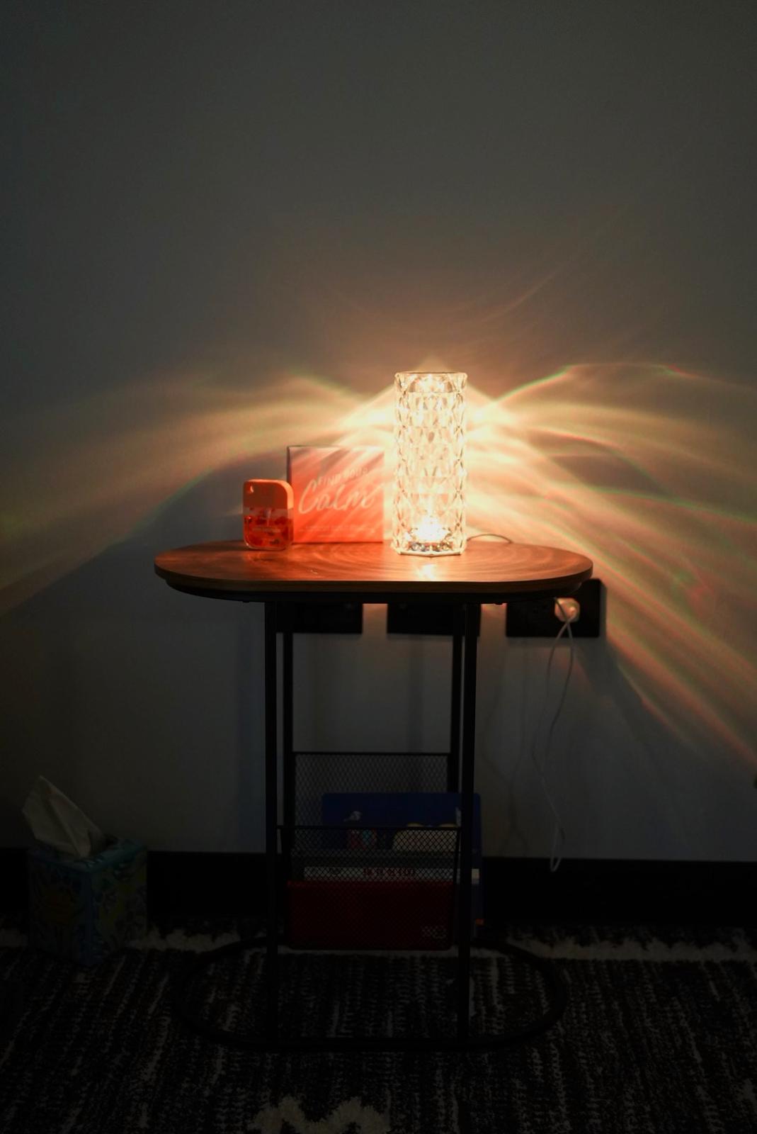 Rincón de la oficina con una mesa y una lámpara de luz cálida.